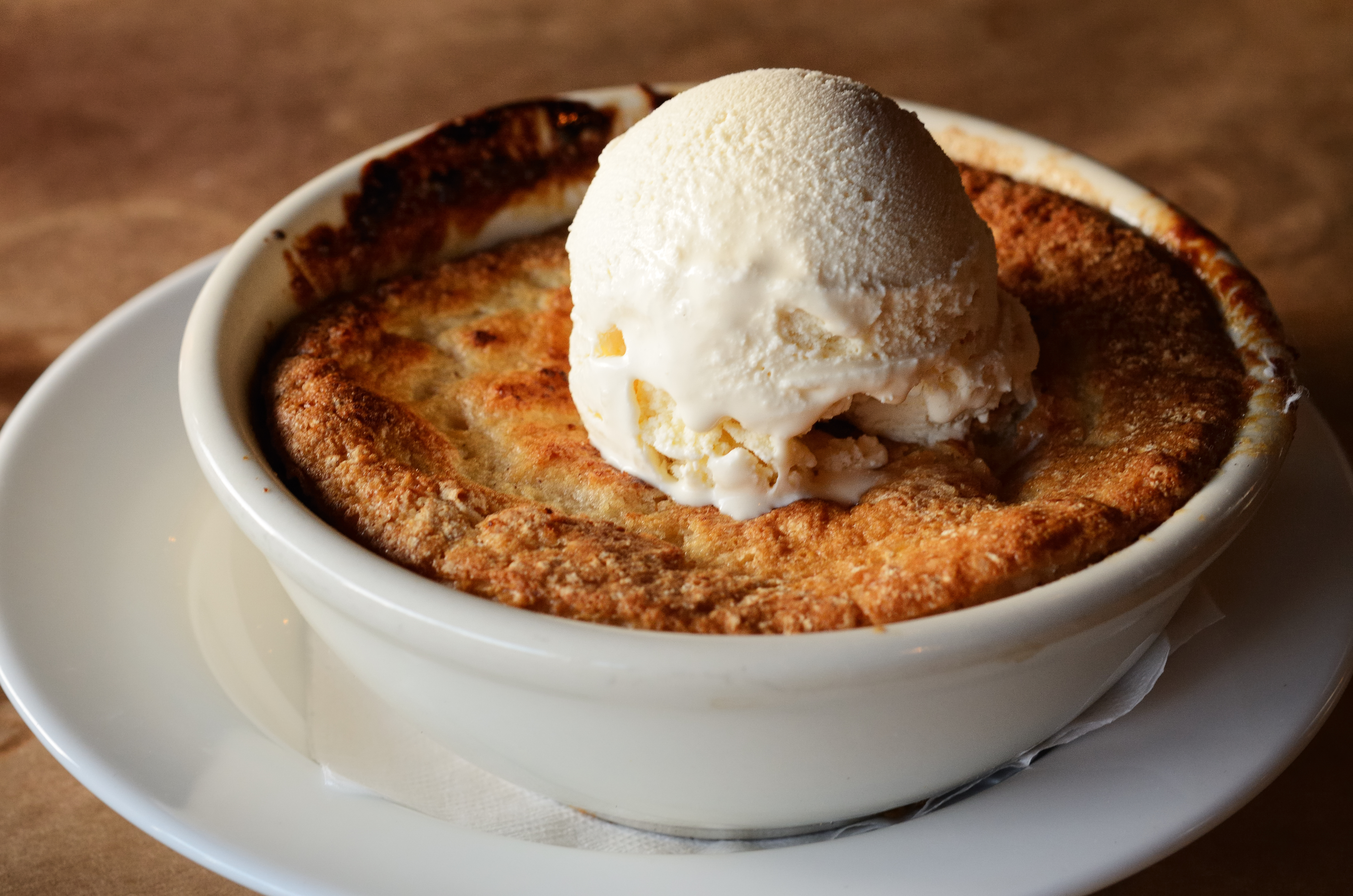 a peach cobbler with vanilla ice cream on top