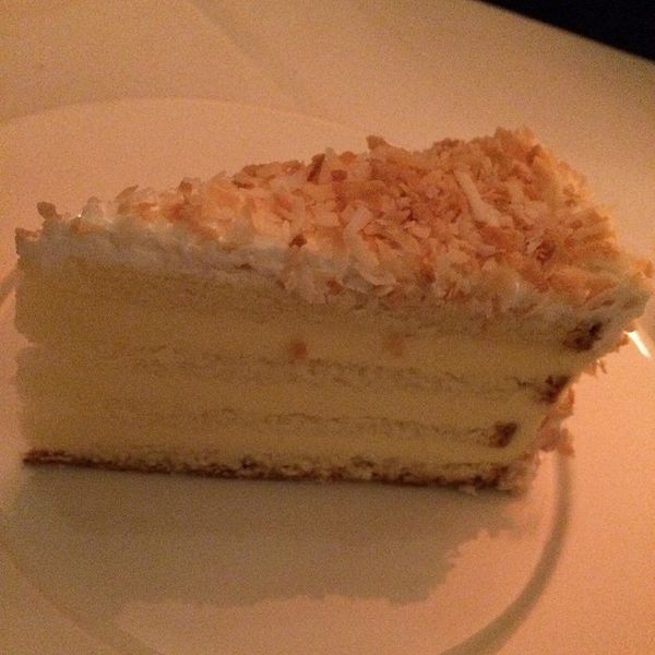 a slice of coconut layer cake on a plate