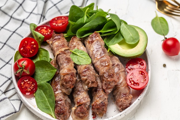 Bacon-wrapped tomatoes with spinach and avocado garnishing