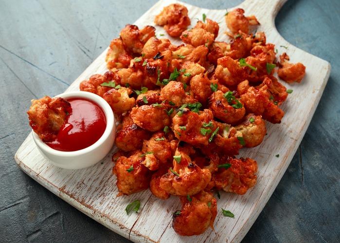 Cauliflower wings on white wooden board