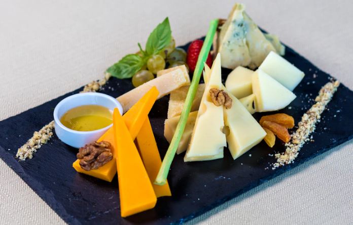 sliced cheeses garnished with nuts