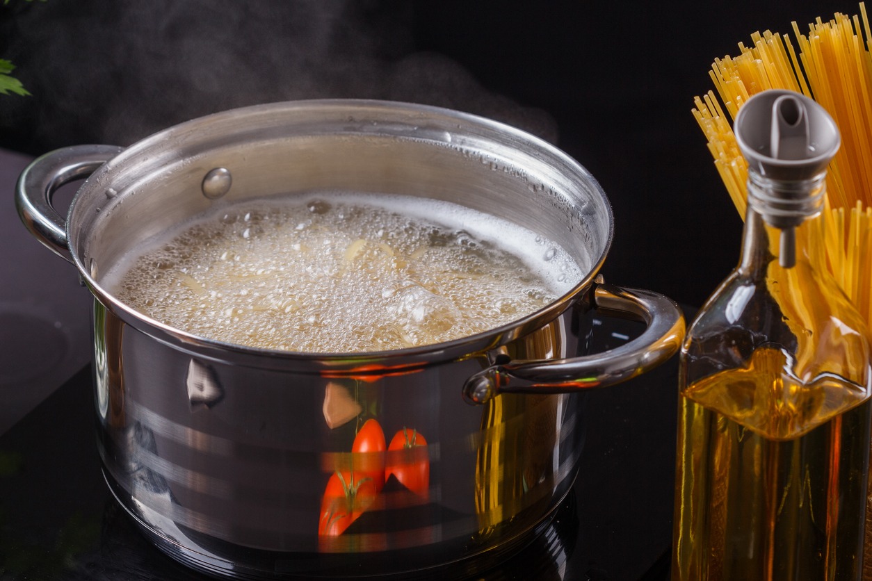 Boiling water with oil and spaghetti aside
