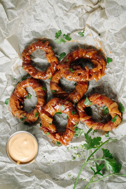 Bacon wrapped onion rings on parchment paper