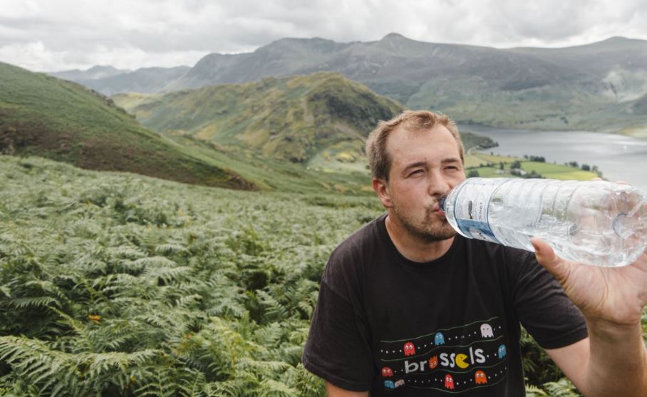 male-traveler-drinking-water-in-nature