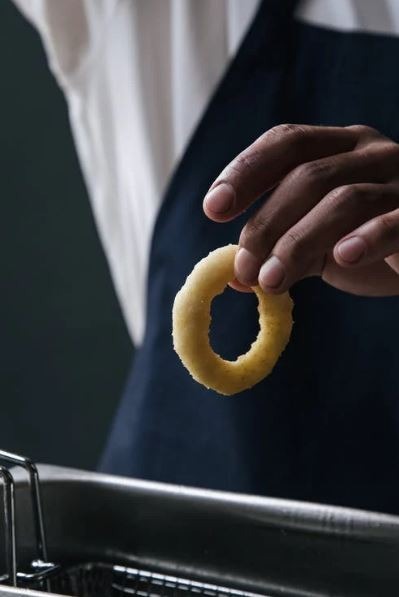 A man holding an onion ring